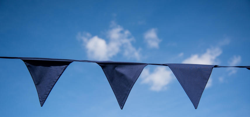 A string of dark blue bunting against a blue sky