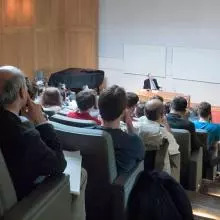 A lecture theatre audience look towards a person on stage