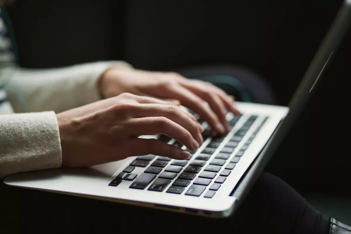A close up of hands on a laptop keyboard