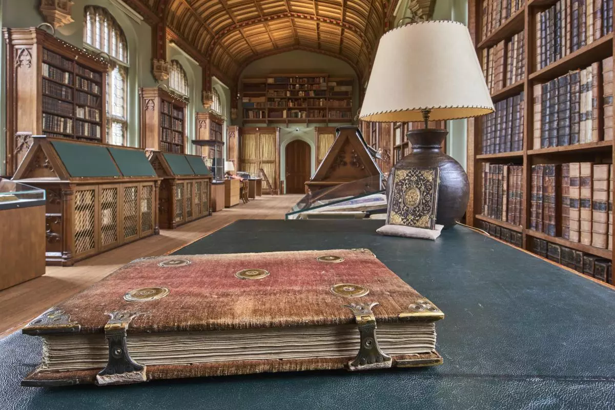 An impressive library with book stacks to either side and large desk in the foreground