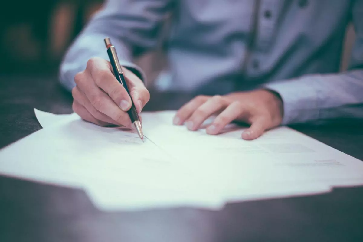 Person writing on paper at a table